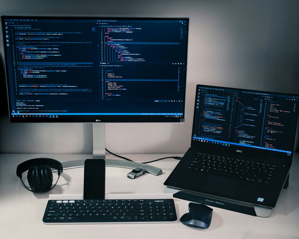 Bureau de travail avec du code sur un écran et un ordinateur portable